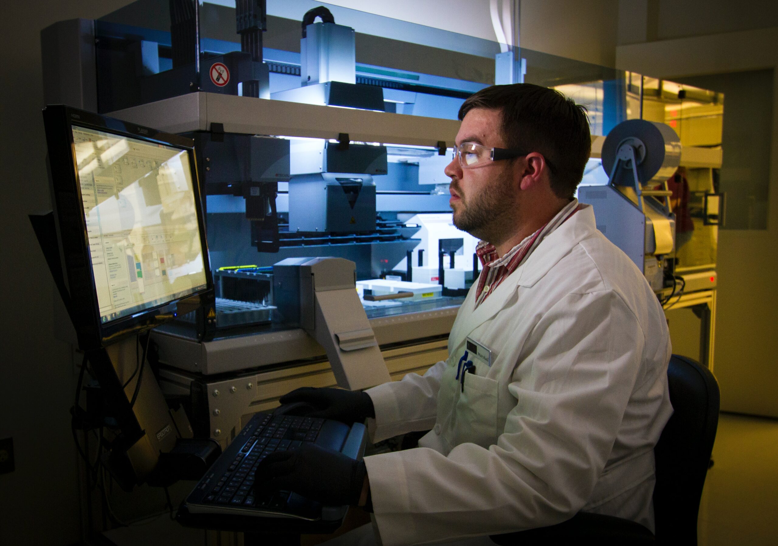 person with lab coat works on computer